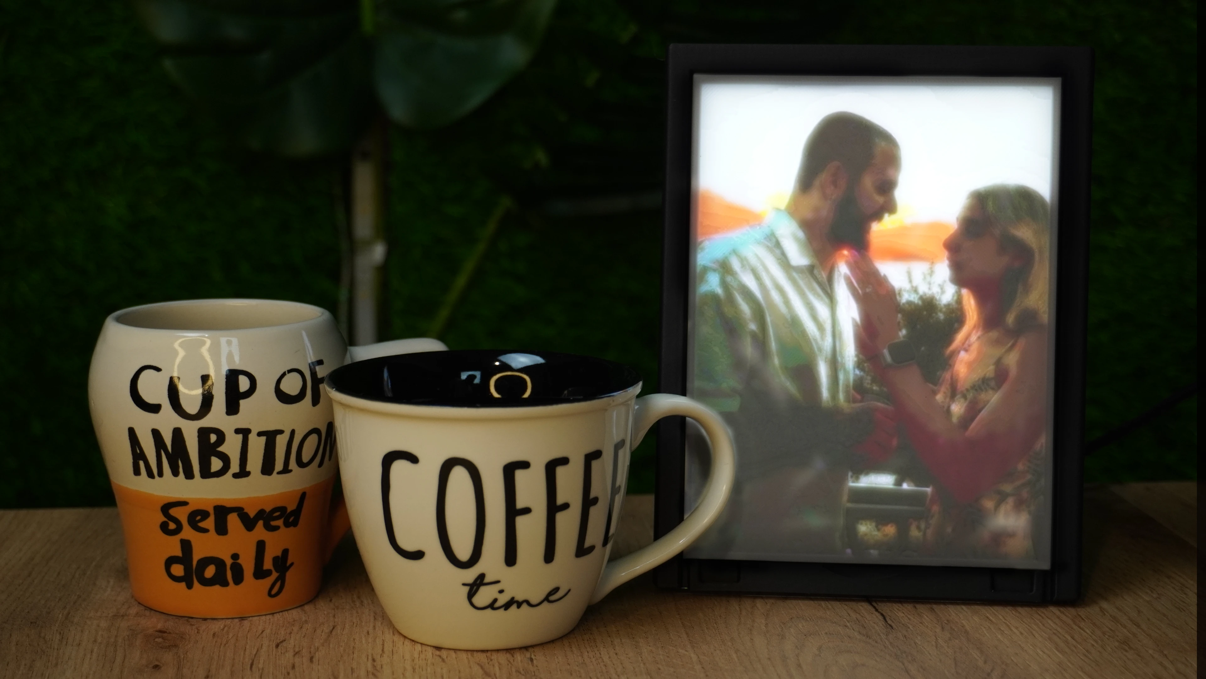 A lit custom lithophane displayed beside two mugs